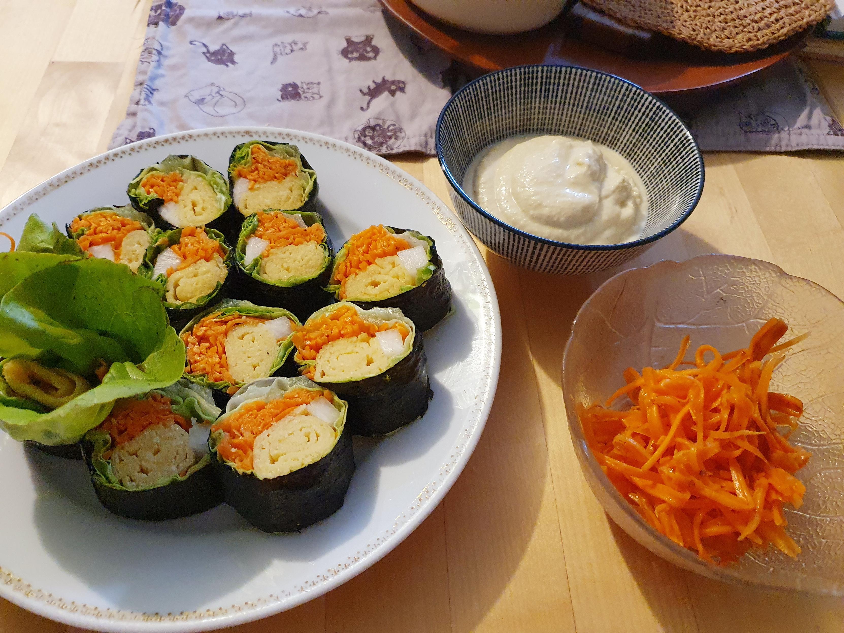 Kimbab ohne Reis auf dem weißen Teller(links) und Karotten-Rapee im Glasschüsselchen daneben(rechts vorne) und Sojamayo im blauen Schüsselchen (rechts oben)