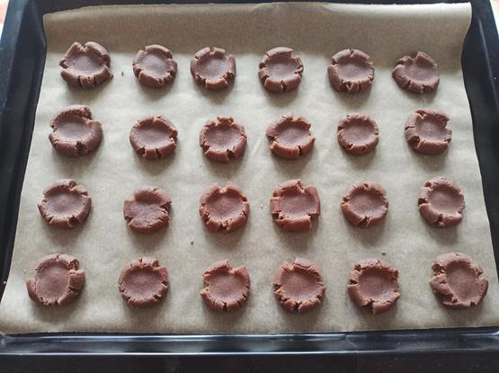 Ein Backblech mit vorbereiteten braunen Schmalzplätzchen 