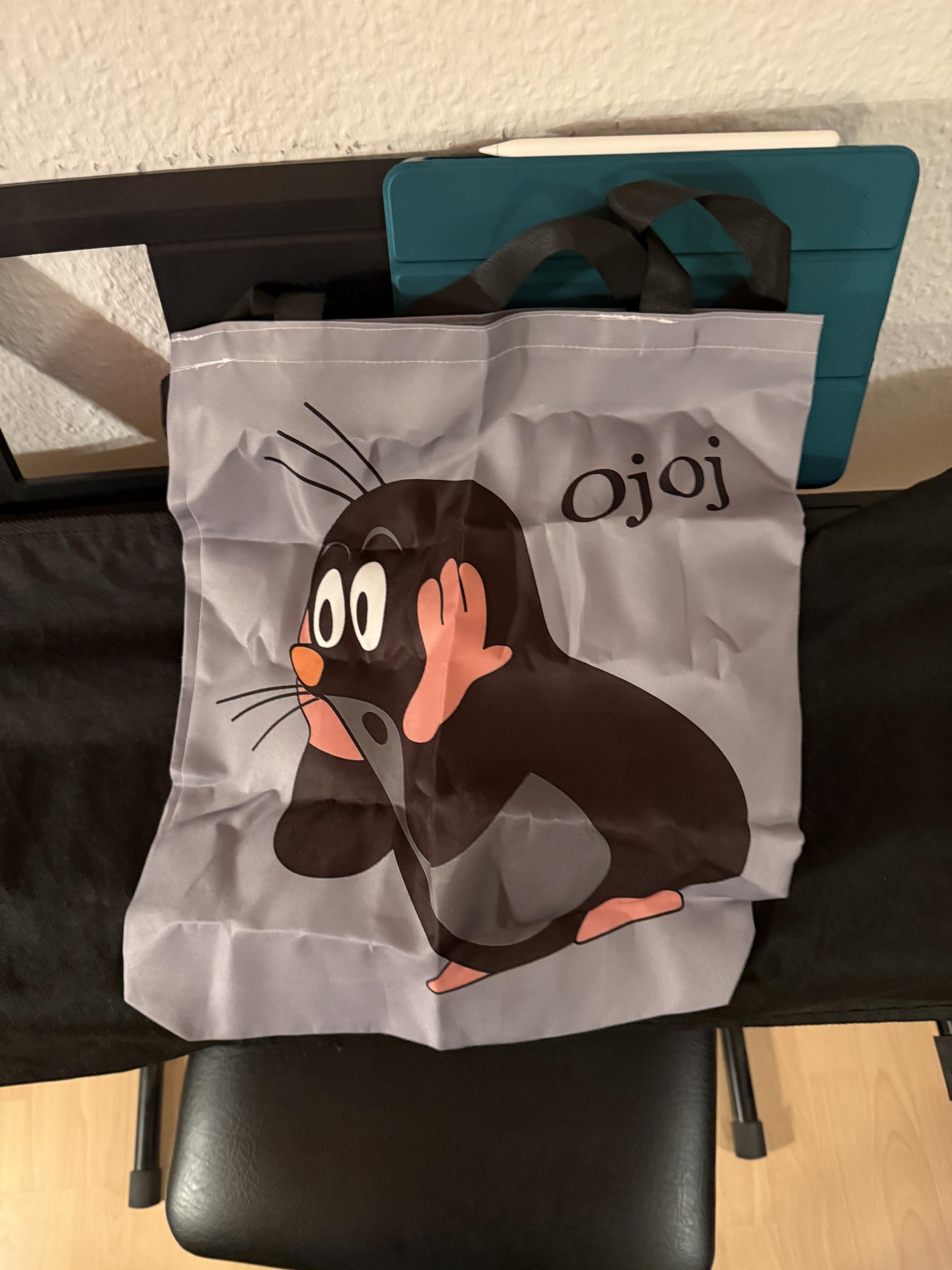 Mehrzweckstoffbeutel mit dem kleinen Maulwurf von Zdeněk Miler. Der Maulwurf guckt darauf erstaunt und es steht „Ojoj“ daneben. 
