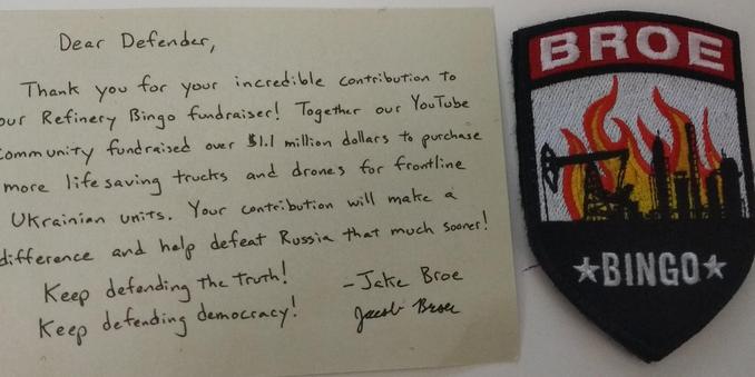 The image displays a handwritten letter on light brown paper next to a shield - shaped patch. The letter reads: "Dear Defender, Thank you for your incredible contribution to your Refinery Bingo fundraiser! Together our YouTube community fundraised over $1.1 million dollars to purchase more lifesaving trucks and drones for frontline Ukrainian units. Your contribution will make a difference and help defeat Russia that much sooner! Keep defending the truth! Keep defending democracy! - Jake Broe Gu…