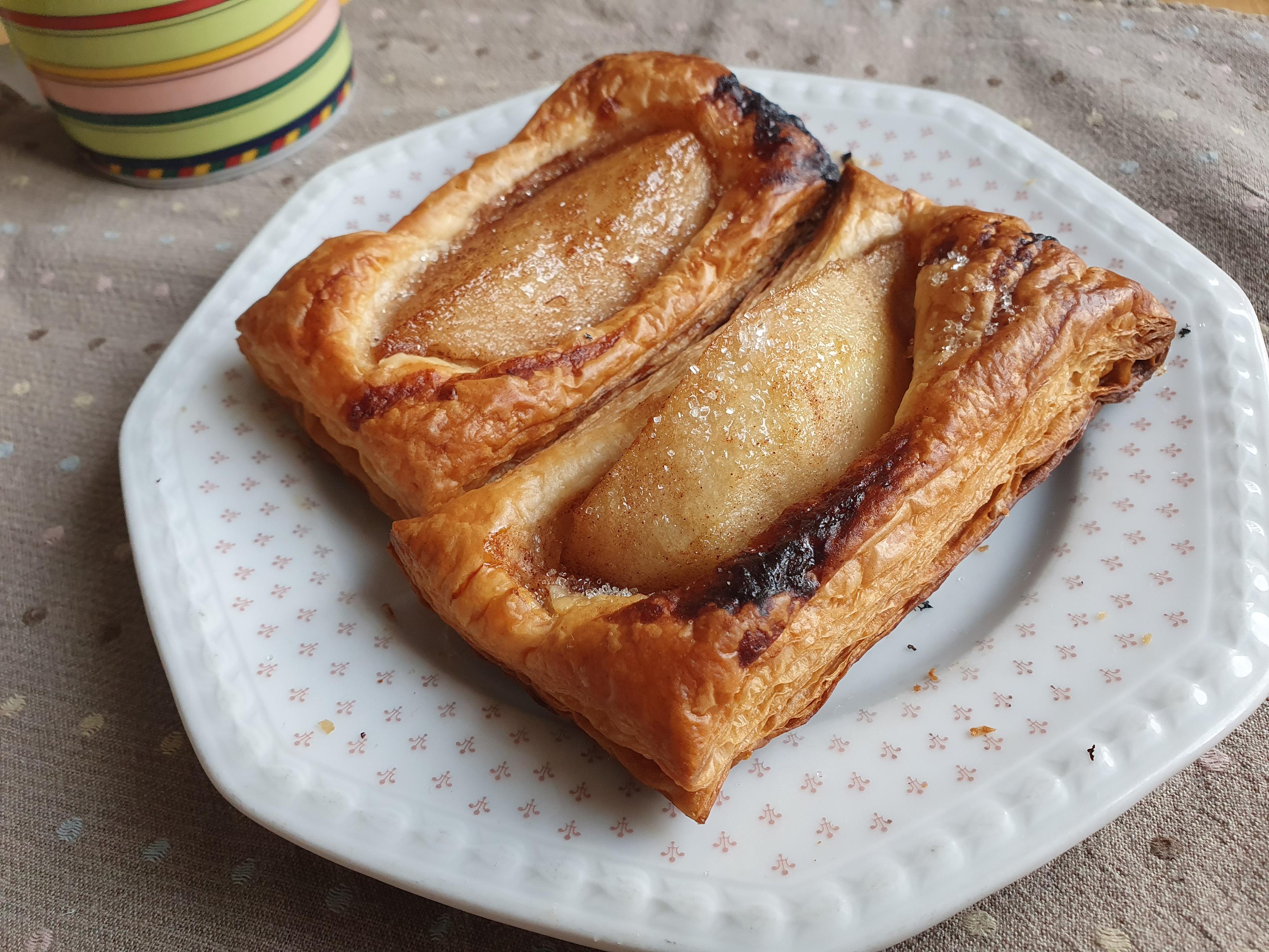 Zwei Stรผcke Sรผรgebรคck mit Birnen auf dem eckigen weiรen Tellerchen
