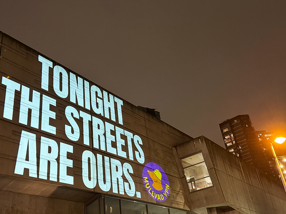 A night-time image of a part of London with the words "Tonight the streets are ours." with the Mullvad VPN logo to the right in a purple circle with yellow writing.
The text "Tonight the streets are ours" have been projected onto a wall of a building with the night sky in the background.