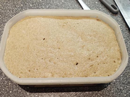 Aufgegangener Sauerteig in einem Becher.