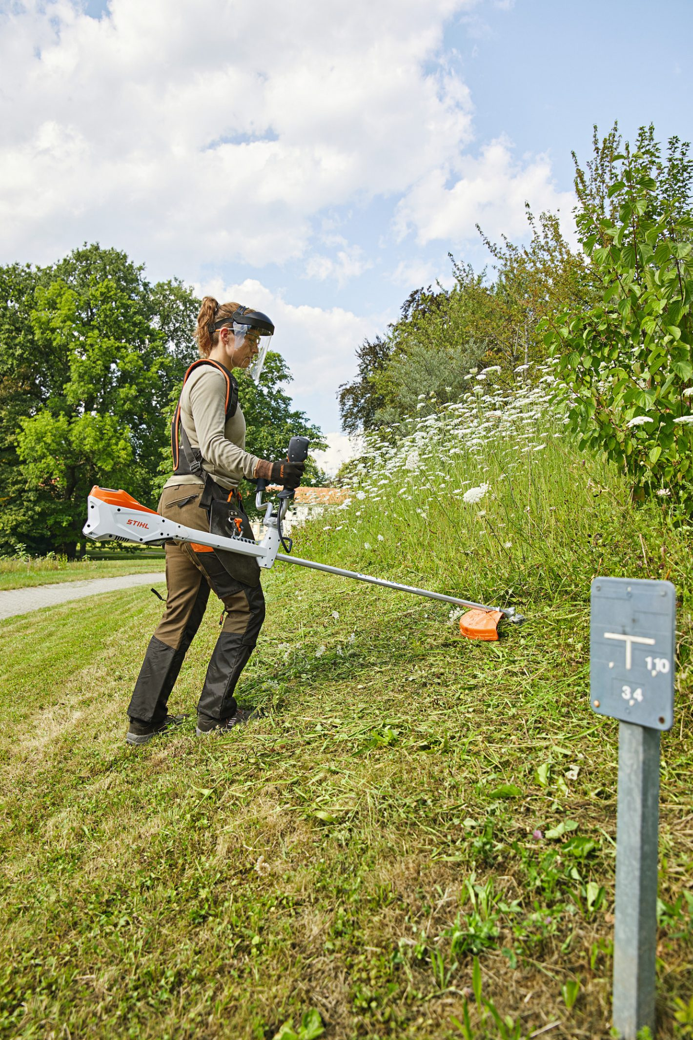 Stihl promo photo showing a person wearing a lot of PPE cutting some flowers.