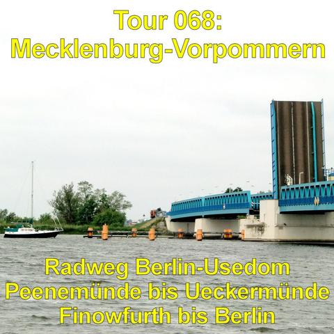 Breiter Fluss mit leicht bewegter Wasseroberfläche. Links liegt ein kleines Segelboot nahe dem Ufer. Rechts überspannt eine moderne Klappbrücke mit blauem Geländer das Gewässer. Ein Brückenteil ist hochgeklappt und steht nahezu senkrecht. Mehrere orangefarbene Dalben ragen vor der Brücke aus dem Wasser. Am Ufer wachsen Bäume und Sträucher, dahinter verläuft eine Straße mit einzelnen Fahrzeugen. Der Himmel ist grau und gleichmäßig bewölkt.