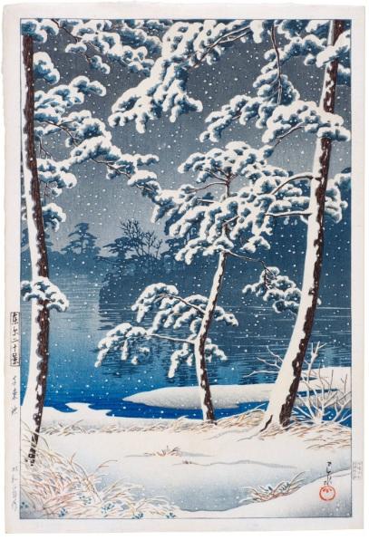 A woodblock print by Kawase Hasui (1883-1957) | Senzoku Pond (Senzoku-ike) | Showa period, 20th century. It shows a snow covered pond shoreline in the foreground with snow covered pine trees on the banks. The blue pond sits in the background.