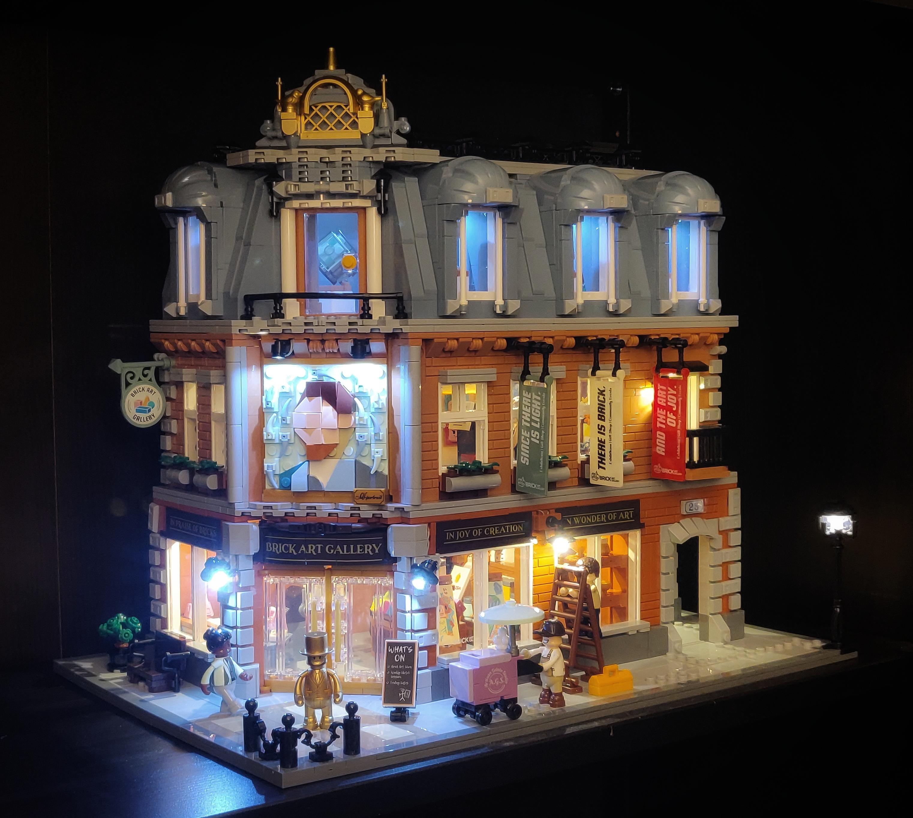 A three-storey corner building made with Lego-like bricks. It's an art gallery with a European architectural style. The ground and middle floors have a tan brick facade, and the top floor is the roof, with a gray blue colour. A self portrait of van Gogh features prominently on the facade. The model has lights both outside and inside, with transparent windows revealing s detailed interior.