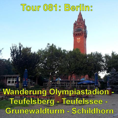 Ein hoher, roter Backsteinturm mit spitzem Dach ragt über die Baumkronen hinaus. Der Turm hat einen Aussichtsbereich unterhalb der Spitze und trägt ein Wappen. Im Vordergrund befindet sich ein Biergarten mit leeren Tischen und Stühlen sowie geschlossenen Sonnenschirmen. Die Umgebung ist von Bäumen umgeben, die den unteren Teil des Turms teilweise verdecken. Der Himmel ist hell und wolkenlos.