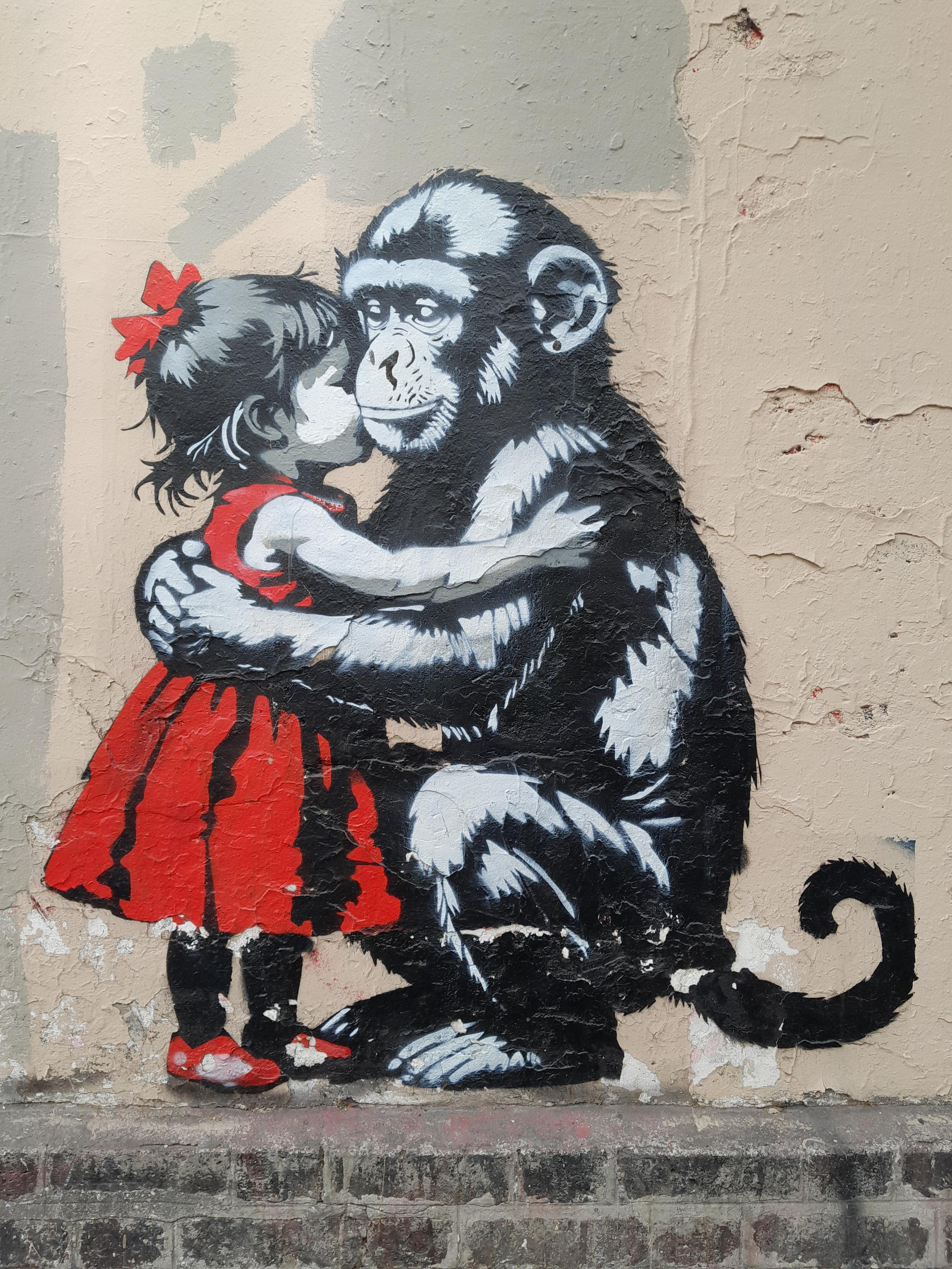 Graffiti showing a #monkey who cuddles a #girl dressed in #red