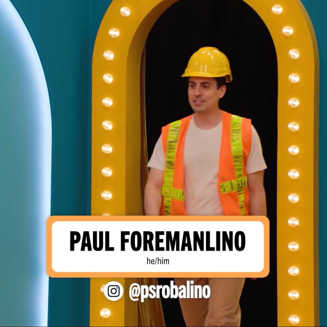 A man in a hard hat and safety vest stands at a brightly lit archway, smiling as he enters a colorful setting.