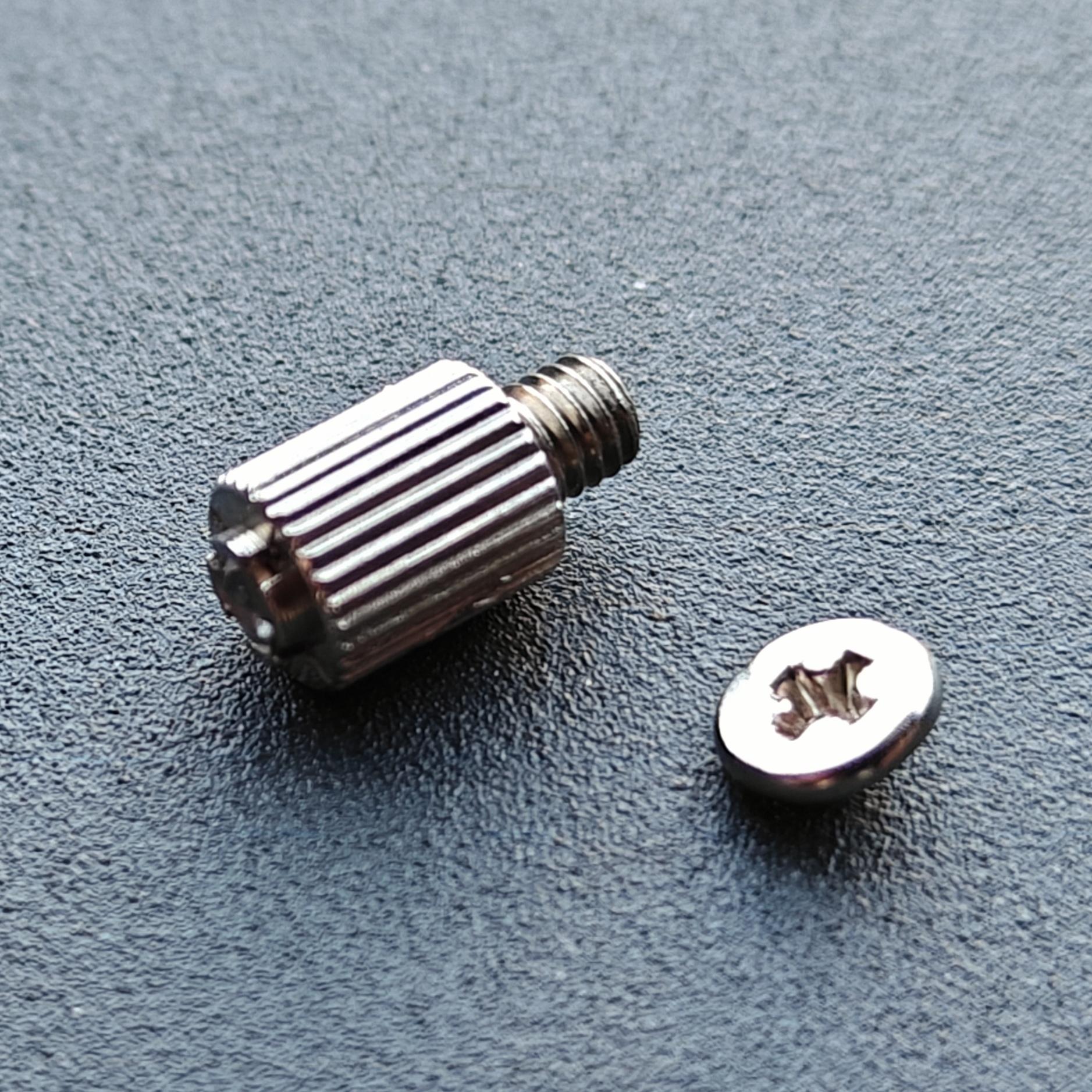 Motherboard M.2 stand-off from a different angle, with the broken-off screw head next to it.