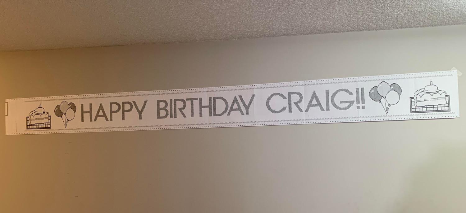 a "banner" saying "HAPPY BIRTHDAY CRAIG!!" with really awful pixel clipart of slices of cake, printed using The Print Shop software on a linefeed printer.