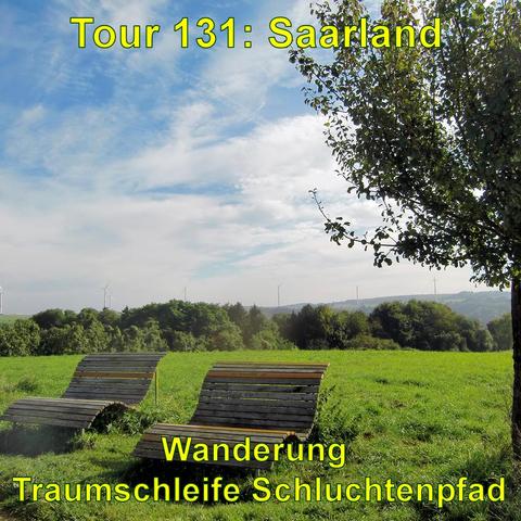 Zwei hölzerne Liegebänke auf einer sonnigen Wiese, die zum Entspannen einladen. Im Hintergrund eine Landschaft mit grünen Bäumen und Sträuchern. Am Horizont sind Windkraftanlagen zu sehen. Der Himmel ist mit leichten Wolken bedeckt, die das Licht der Sonne streuen. Ein Baum im Vordergrund rechts ergänzt die ländliche Szenerie.