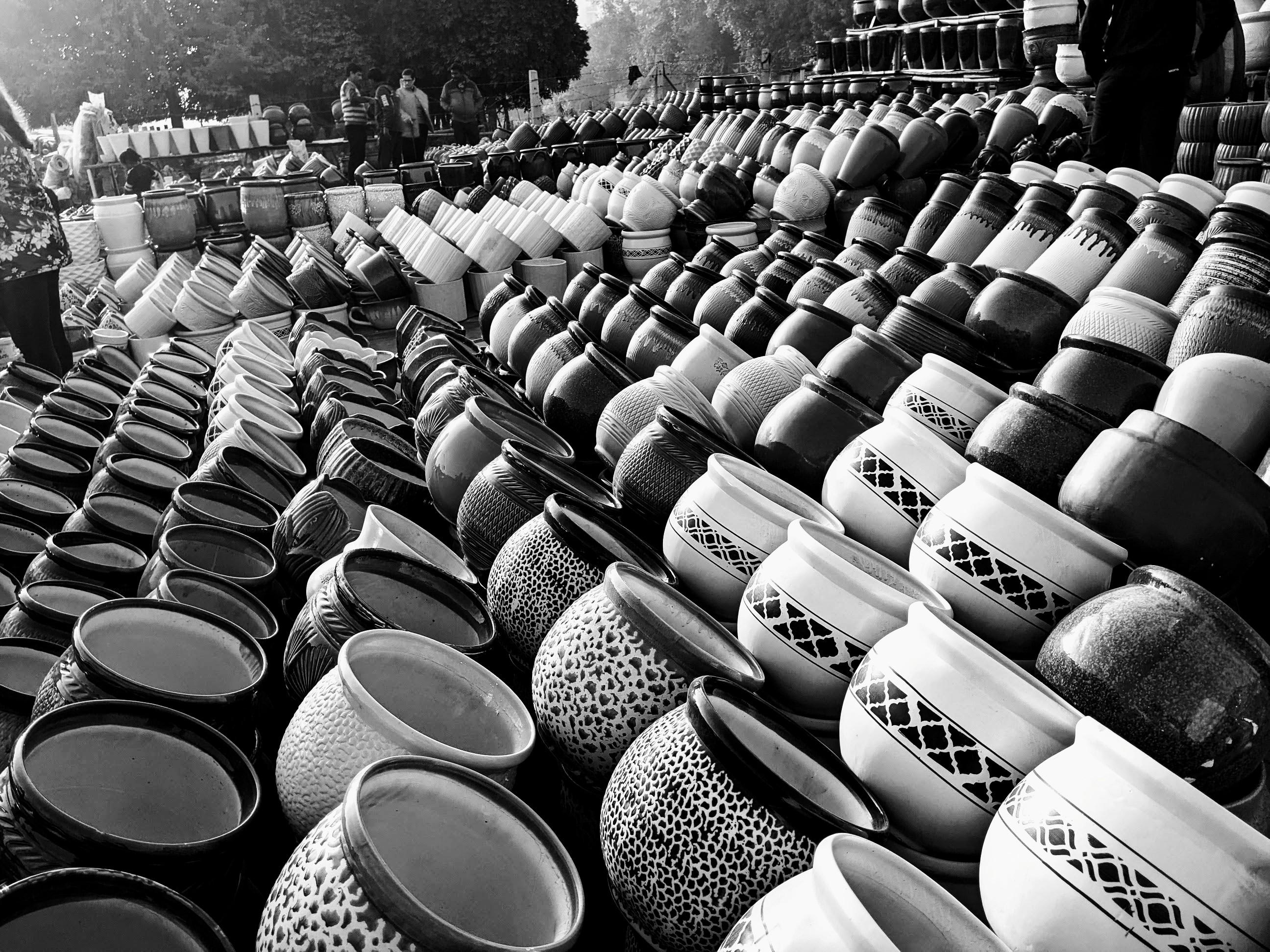 Rows of large pots almost as far as the eye can see - all stacked and tilted so they are resting on their sides.
