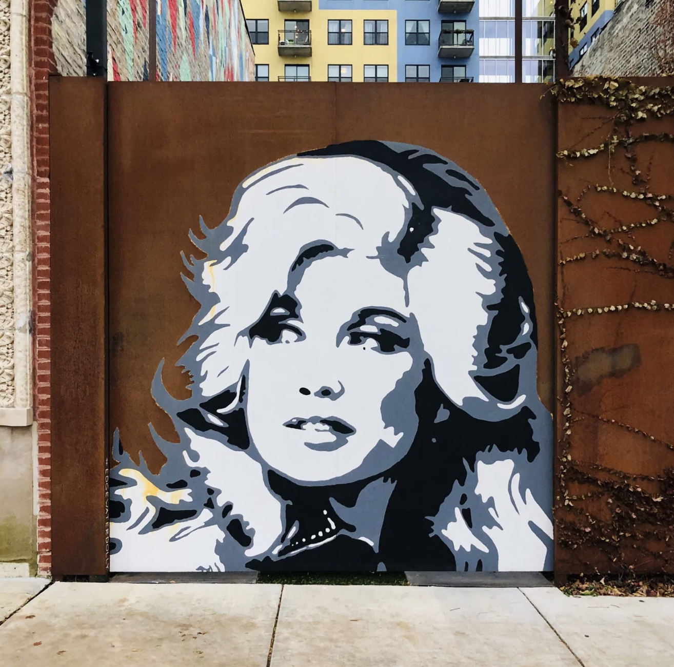 Michelle Lytle’s black-and-white portrait of Dolly Parton painted on a rust-colored gate at The Lytle House in Chicago