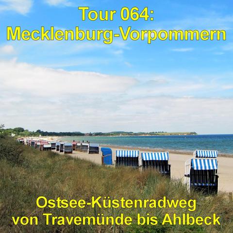 Sandstrand an der Ostsee mit einer Reihe von blau-weiß gestreiften Strandkörben, die in gleichmäßigem Abstand entlang der Küste stehen. Im Vordergrund wachsen Dünengräser auf einem leicht erhöhten, grasbewachsenen Uferstreifen. Das Meer zeigt eine klare, blaugrüne Färbung mit sanften Wellen. Einige Menschen sind in der Ferne am Wasser unterwegs. Die Küstenlinie zieht sich weit nach links und endet an einer flachen, begrünten Landzunge. Der Himmel ist blau mit ausgedehnten, hellen Wolkenfeldern.