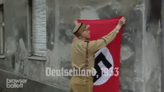 Germany in 1933: a person calls a uniformed SS officer a n*zi, and the officer challenges that "assumption" and says he is just a concerned citizen, and asks a nearby n*zi soldier if he (the SS officer) looks like a n*zi, and the n*zi soldiers says no, and so the officer says the person probably thinks the n*zi solider is a n*zi too and even says the person probably thinks the the führer is a n*zi too. The person says yes, so the SS officer takes the person into custody for insulting the führer.