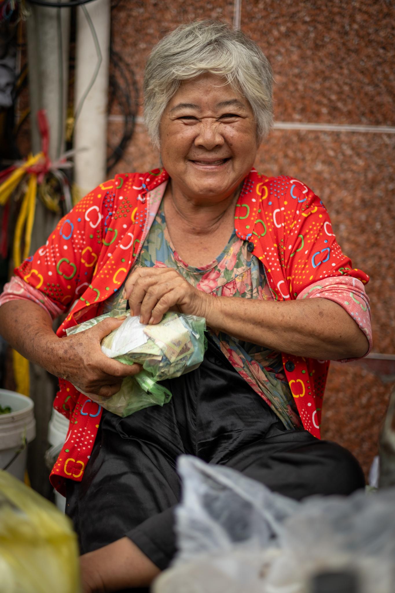A street vendor smiles at the camera.