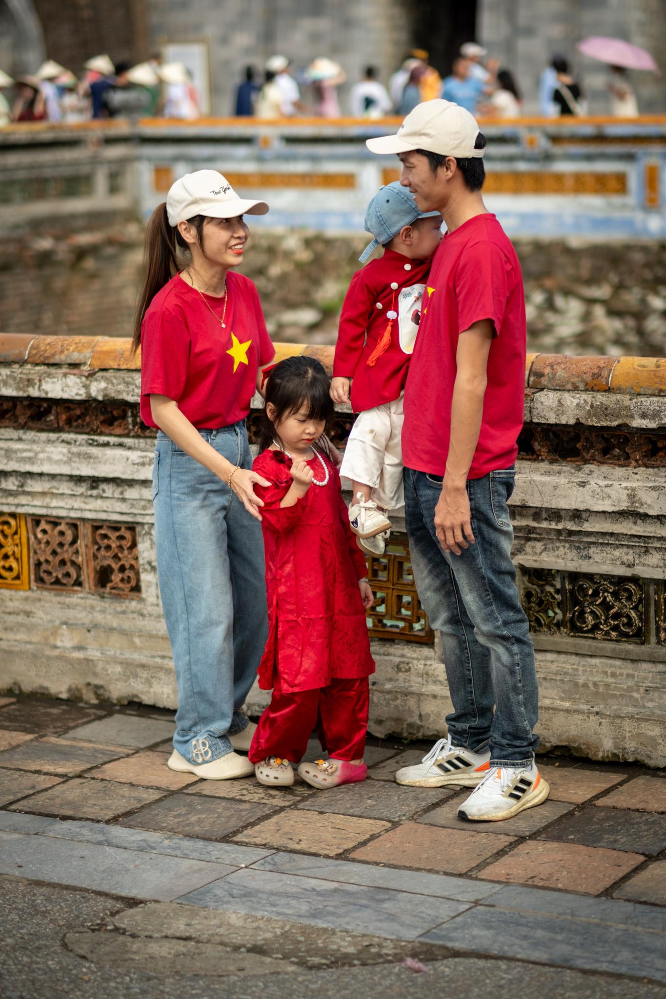 A family with two small children dressed in red at the September 2 celebrations in Hue.