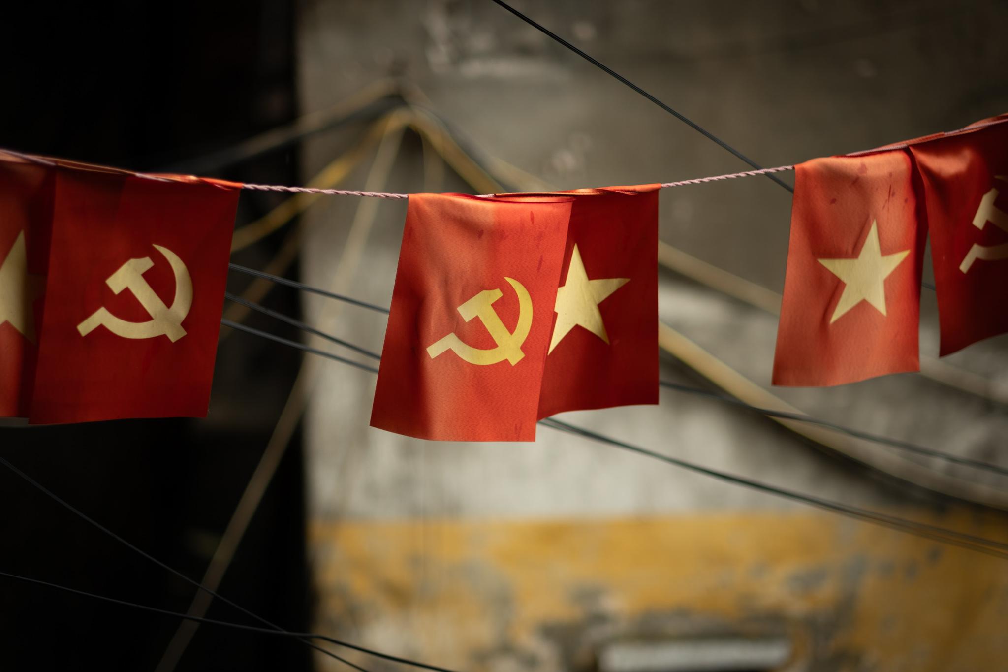 A line of red flags, with alternating star and hammer/sickle symbols on the little flags.